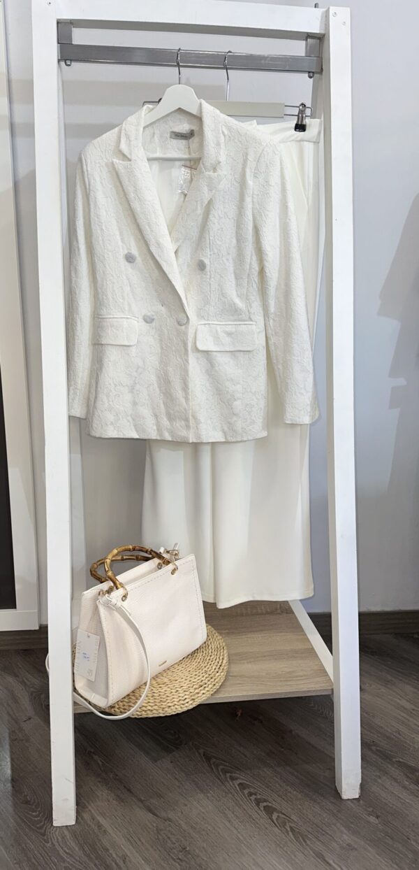 Traje blanco elegante de chaqueta y falda de encaje, combinado con bolso de cuero de asa de bambú. Disponible en Arezzo, tienda online de moda y complementos femeninos, para un look sofisticado y moderno.