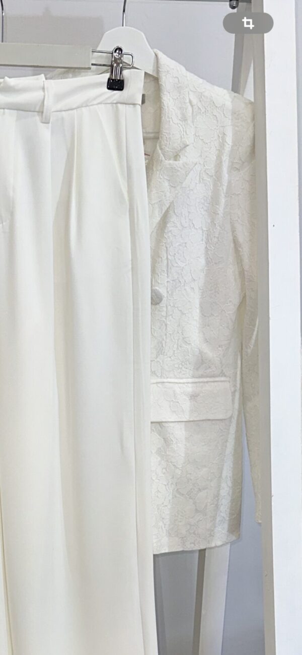 Conjunto elegante de chaqueta de encaje y pantalón blanco para mujer en Arezzo, tienda de moda y complementos. Ideal para eventos sofisticados.