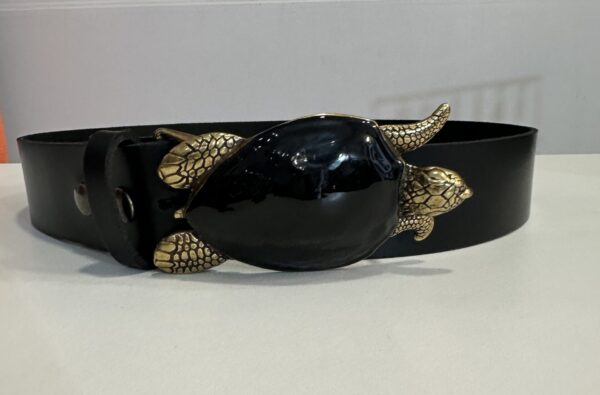 Cinturón elegante de cuero negro para mujer de la colección Arezzo, con hebilla en forma de tortuga dorada, ideal para añadir un toque sofisticado a cualquier conjunto. Perfecto para complementar tu look con estilo y originalidad.