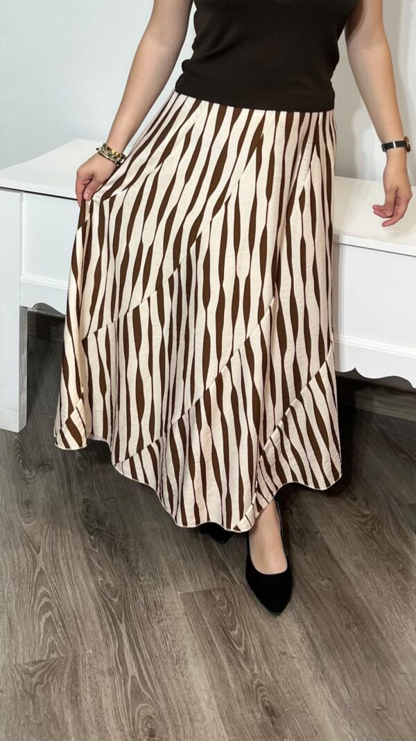 Falda midi con estampado a rayas en tonos marrón y beige, ideal para un look elegante y moderno. Disponible en Arezzo, tienda online de moda femenina. Combínala con tus complementos favoritos para un estilo único.