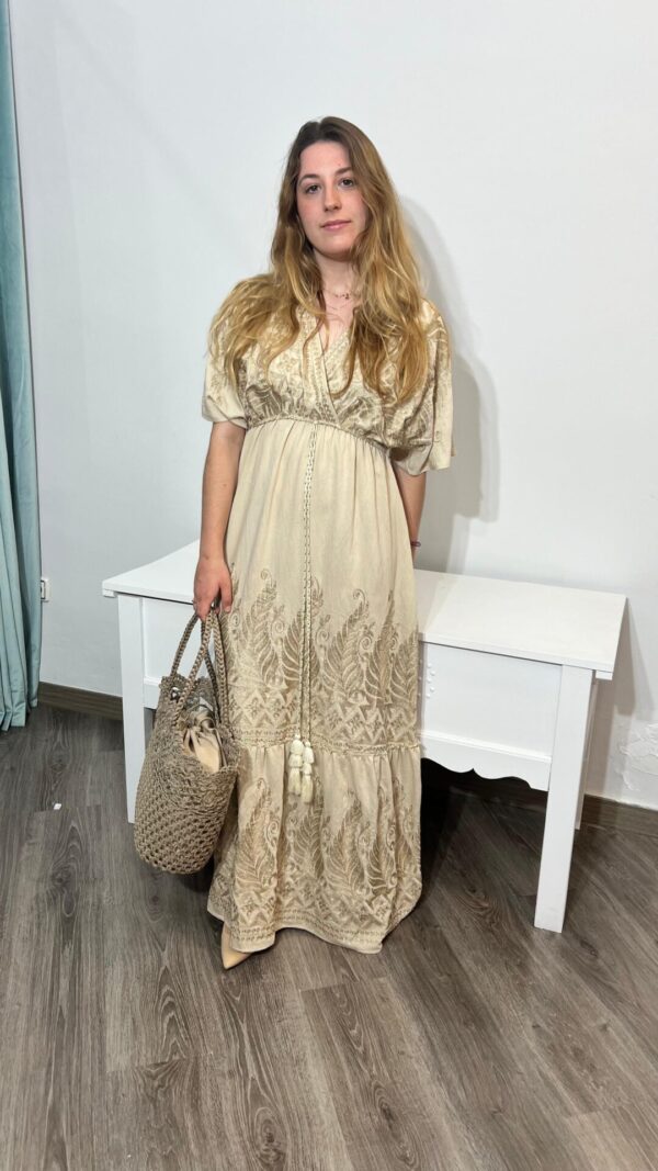 Vestido bohemio beige con delicados bordados florales, ideal para un look de verano elegante. Complementa tu estilo con bolso de paja artesanal disponible en Arezzo, tienda online de moda